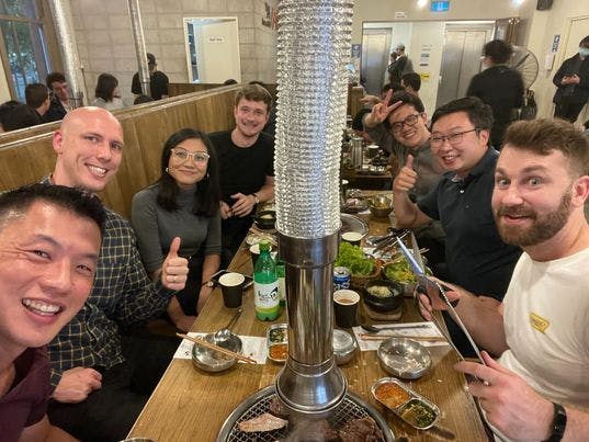 Faethm team at Korean BBQ eating and drinking and smiling at the camera