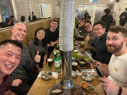 Faethm team at Korean BBQ eating and drinking and smiling at the camera